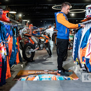 Biker jackets and motorbikes in a showroom with an advertising mat