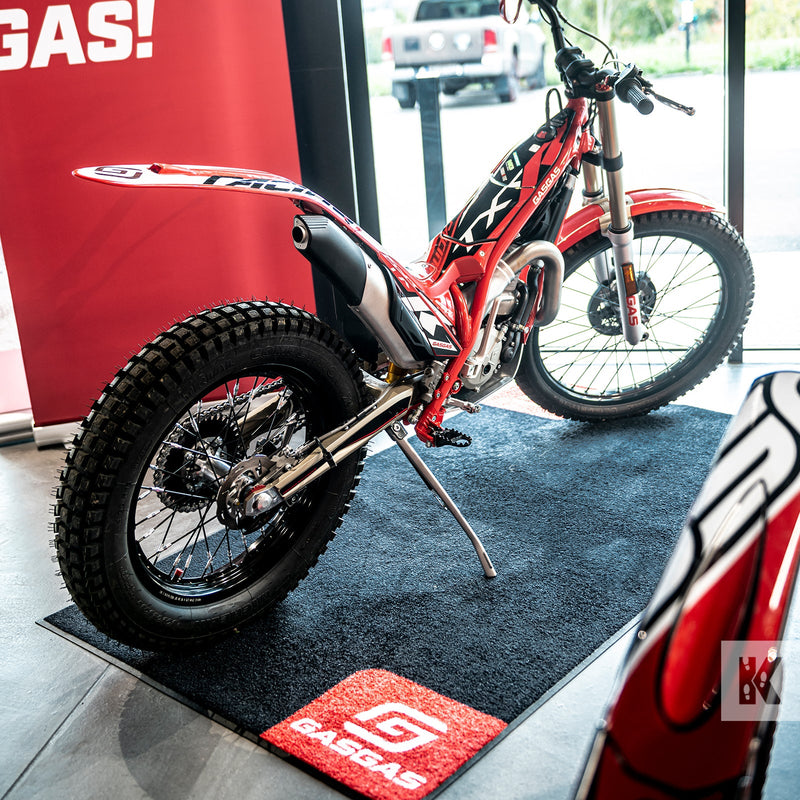 Dirtbike in a GasGas showroom parked on a Black branded mat