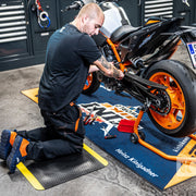 Bike mechanic at work with various floor mats