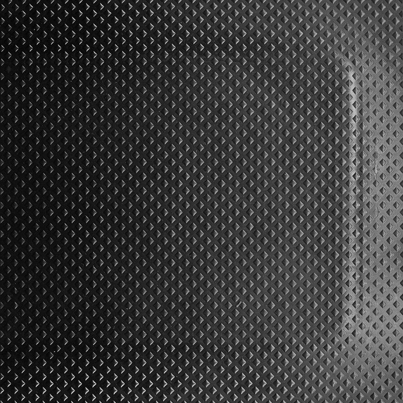 A close-up of a black, rubber anti-fatigue mat with a textured surface.