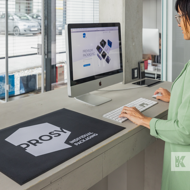 Lady using computer in a reception scene with a printed counter mat