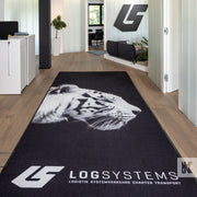 A custom printed indoor rug with a black background featuring a white tiger's face and the branding of 'LOGSYSTEMS' with a logo.