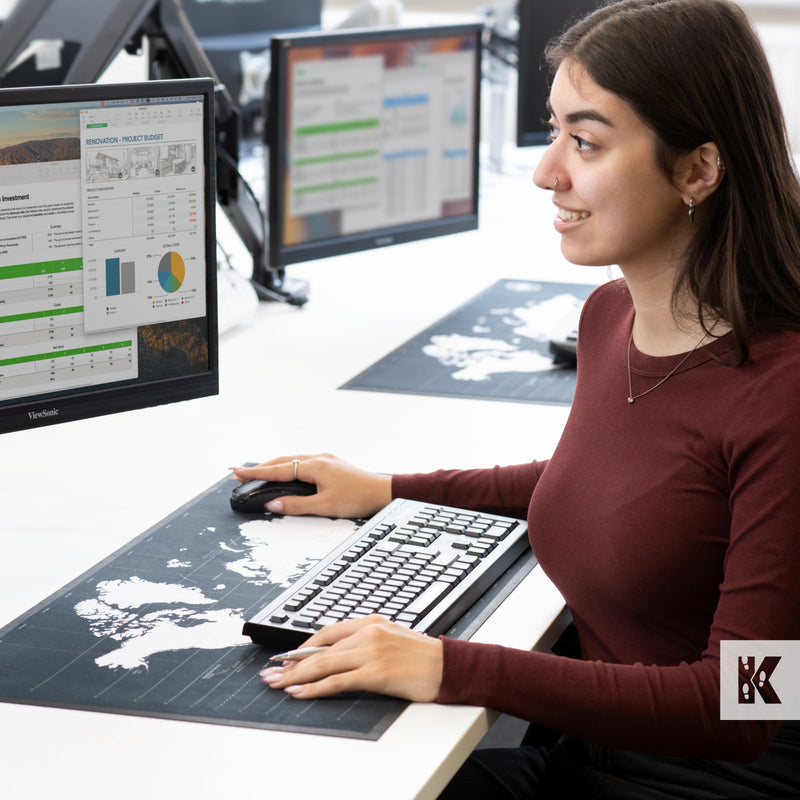 Lady using a computer with a desk planner mat