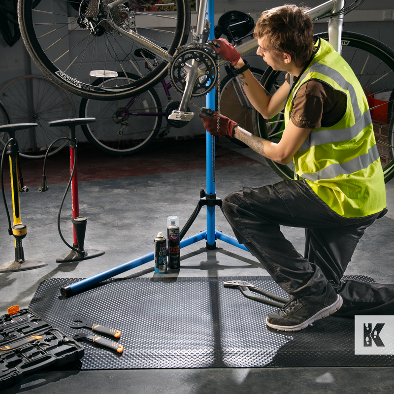Bicycle repair man to the rescue on a kleen-comfort mat