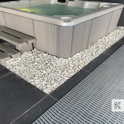 Hot tub with pebbles around it on a tiled patio