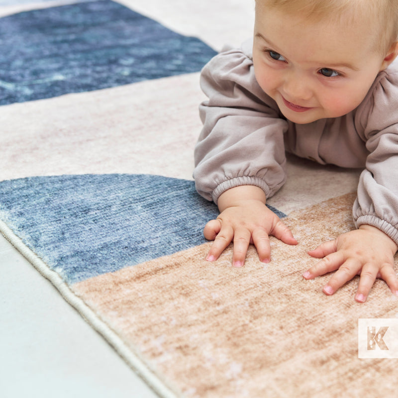 Child playing on a colorful geometric-patterned rug