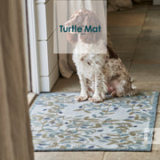 A dog sitting on a blue floral door mat with the text 'Turtle Mat' overlaid on top of the image.