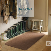 Row of wellies under coat rack with a stool and Turtle Mat before an open door