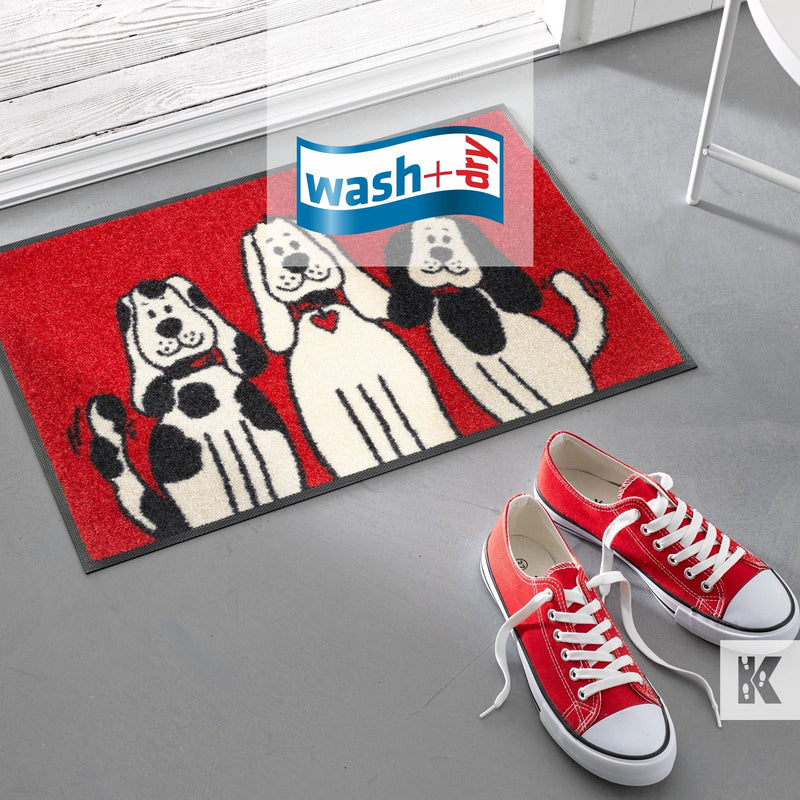 Red sneakers with white laces and a red, black and white printed mat with cute dog cartoon