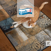Ginger and white cat plays with a toy mouse on a contemporary floor mat